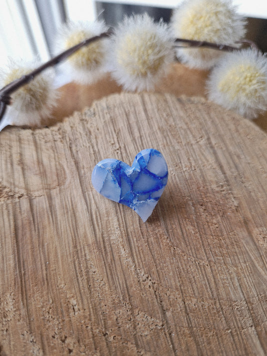 Pin's cœur marbré bleu.